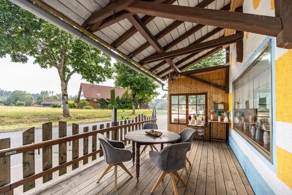 a patio with a table and chairs on a wooden deck at Salty Sol in Leutkirch im Allgäu