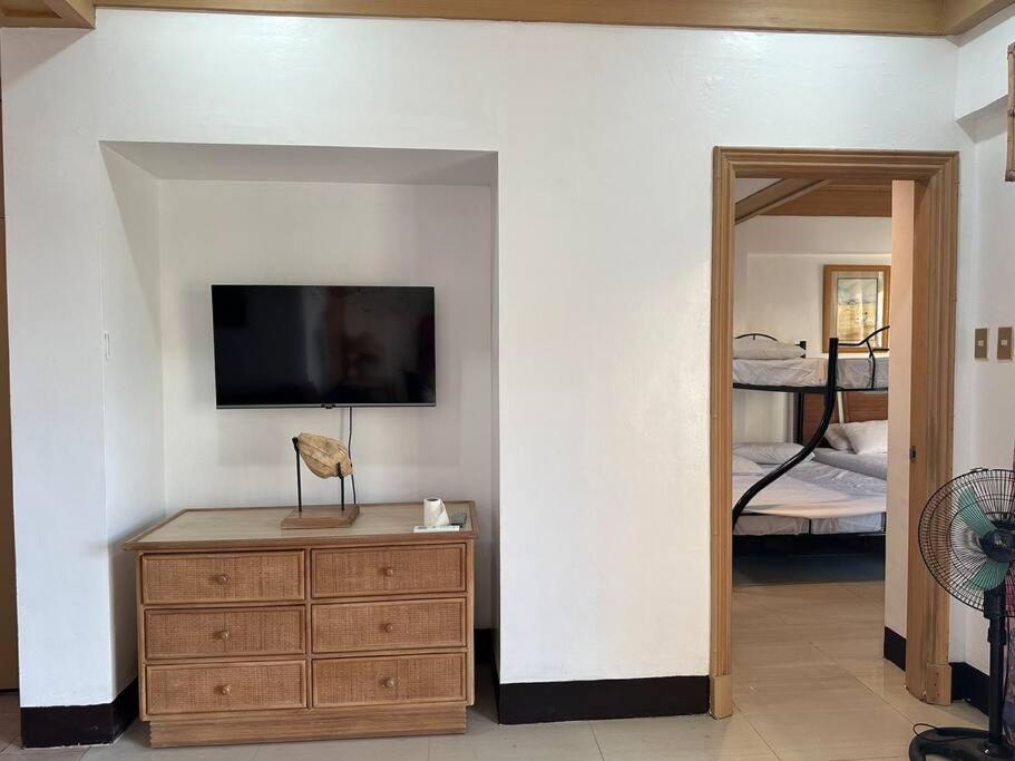 a room with a tv and a dresser and a bedroom at Canyon Cove by Lawton in Nasugbu