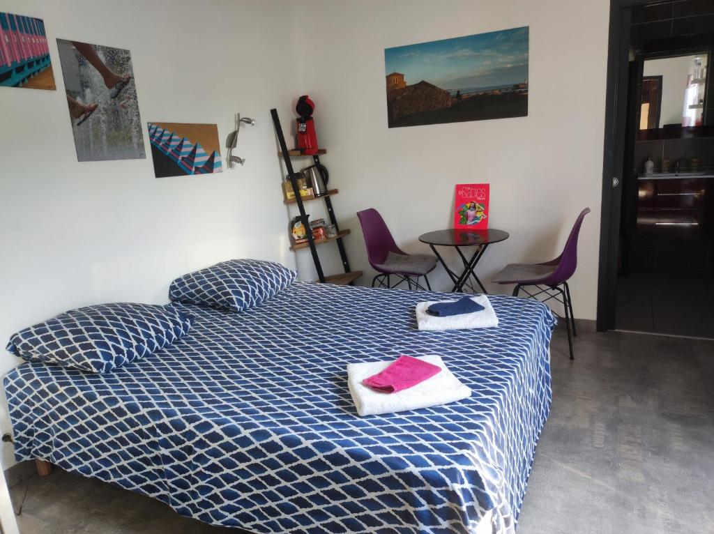a bedroom with a bed with two towels and a table at Chambre et salle d'eau dans dépendance 20 m2, vélos in Les Sables-dʼOlonne