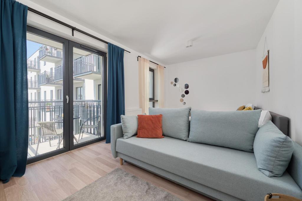 uma sala de estar com um sofá e uma varanda em City Center Mirrors Apartment with Parking by Renters em Breslávia