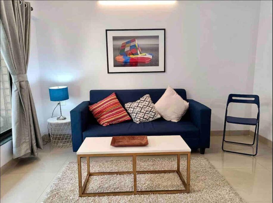 a blue couch in a living room with a table at Matruchaya, off Carter Road by Connekt Homes in Mumbai