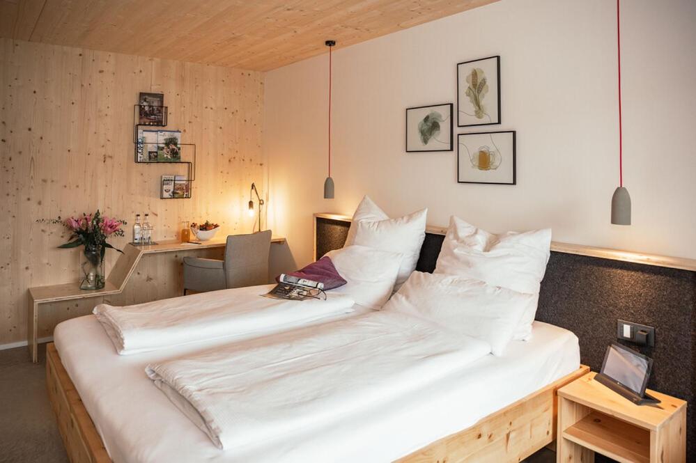 ein großes weißes Bett in einem Zimmer mit einem Schreibtisch in der Unterkunft Allgäuer Genusshotel und Historischer Brauereigasthof Hirsch in Leutkirch im Allgäu