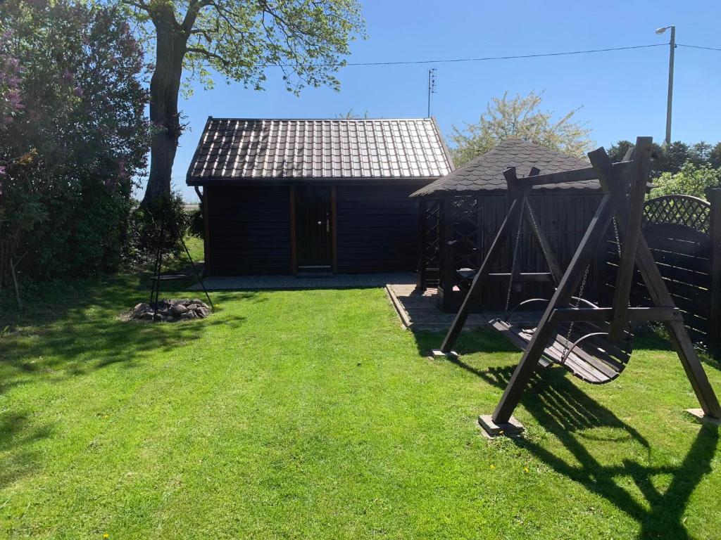 un patio con una casa y un columpio en Domek Letniskowy Wojtek en Gdansk