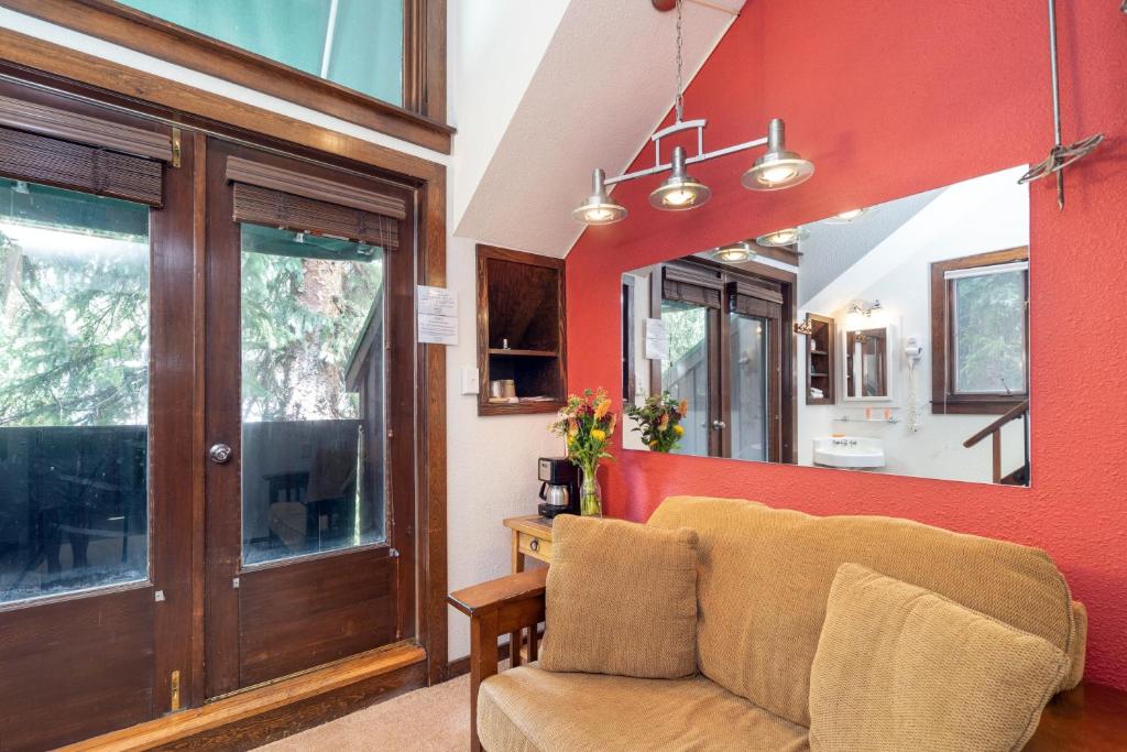 a living room with a couch and a red wall at Manitou Lodge 11 by Alpine Lodging Telluride in Telluride
