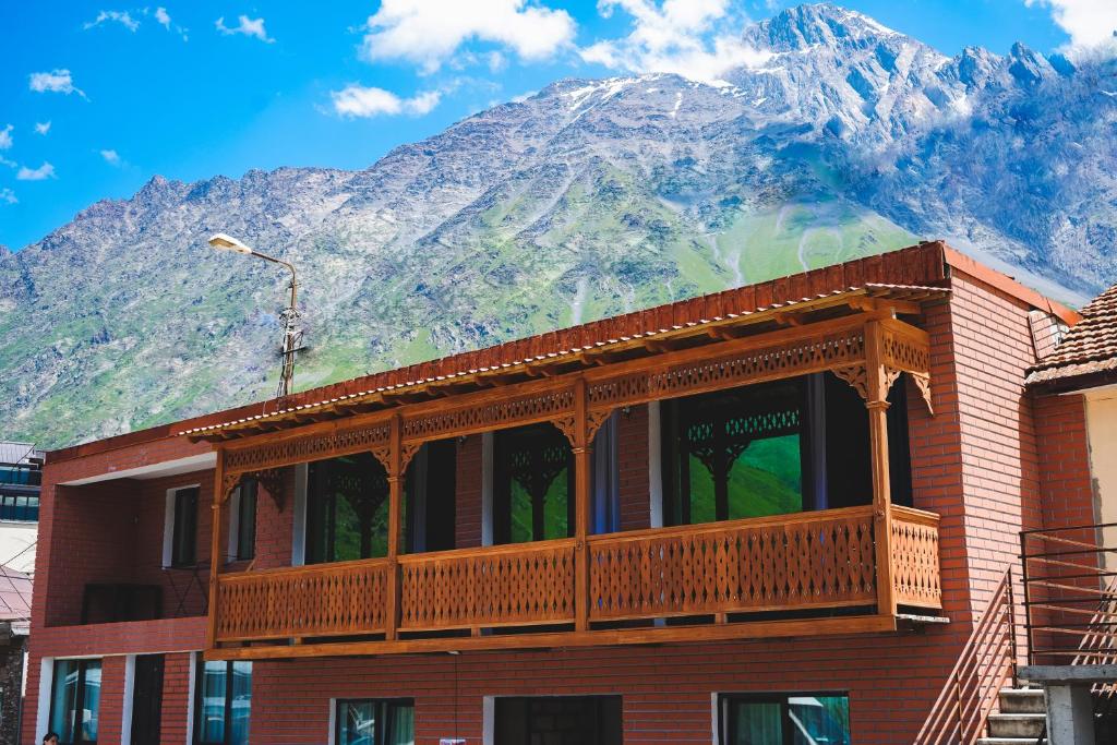 a building with a balcony with a mountain in the background at Fiten house in Stepantsminda