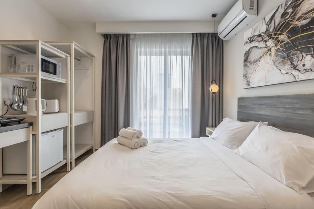 a bedroom with a white bed with a stuffed animal on it at Studio room 11 with kitchenette in the heart of St Julians in Paceville