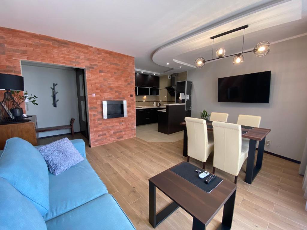 ein Wohnzimmer mit einem blauen Sofa und einer Ziegelwand in der Unterkunft Apartament Toruń in Toruń