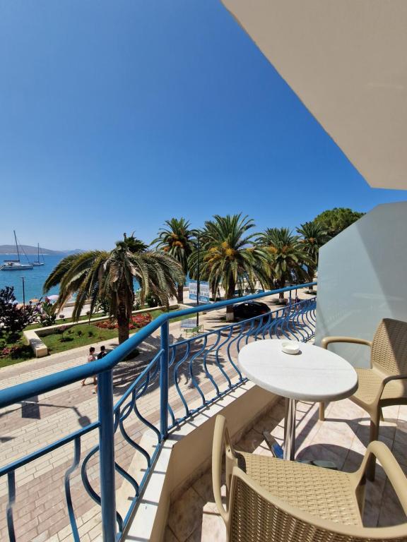 balcón con mesa y sillas y la playa en Hotel Kaonia, en Sarandë