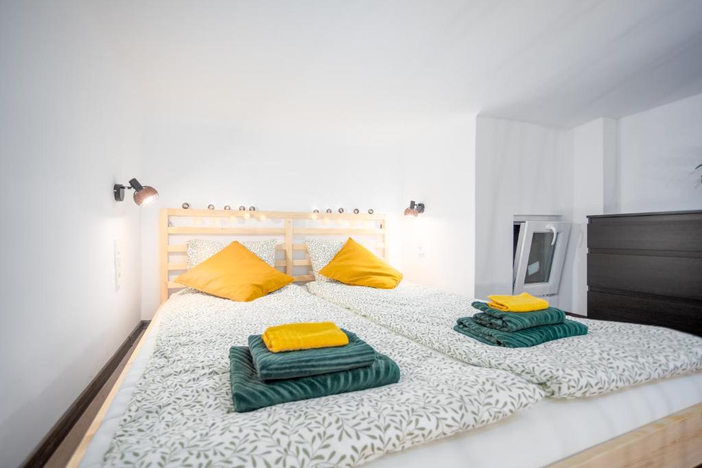 Una cama con dos almohadas verdes y amarillas. en Green Goblin Apartment with FREE PRIVATE PARKING, en Budapest