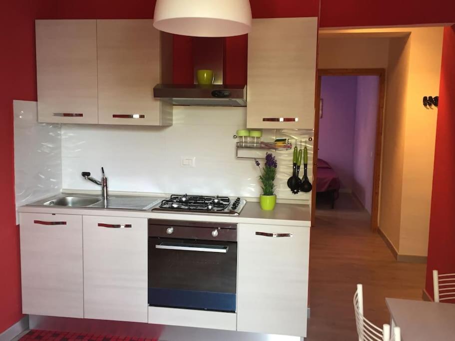 a kitchen with white cabinets and a stove top oven at Trilocale IMMinens mari in Copanello