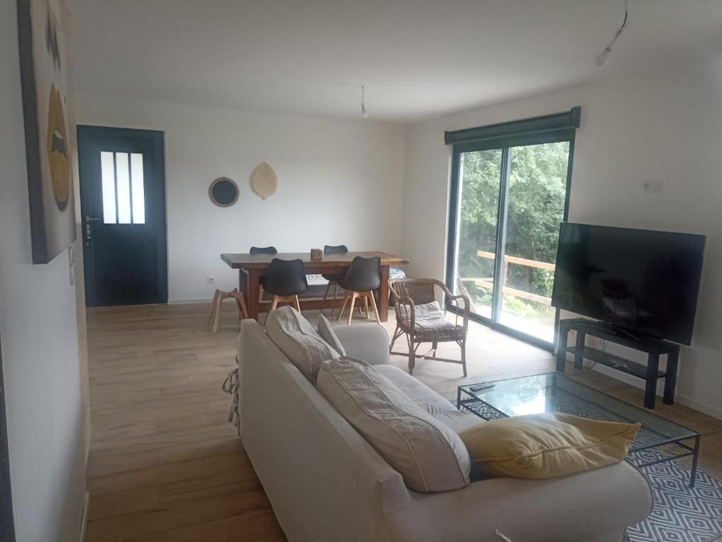 un salon avec un canapé blanc et une table dans l'établissement apatam, à Petit-Berneval