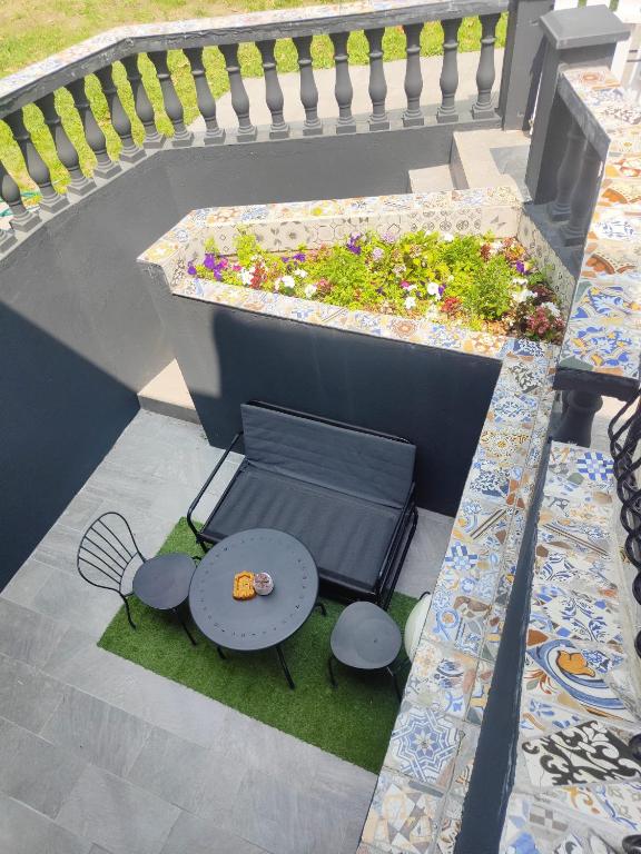 une terrasse avec une table et un planteur de fleurs dans l'établissement Appartement terasse, à Saint-Maur-des-Fossés