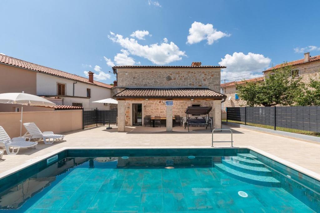 einem Pool vor einem Haus mit einem Gebäude in der Unterkunft Villa Maria Tadini in Kaštelir