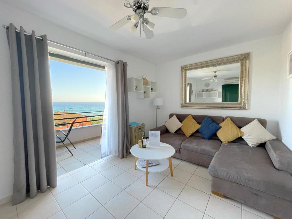 a living room with a couch and a view of the ocean at Bluview, Glyfada, Corfu in Glyfada