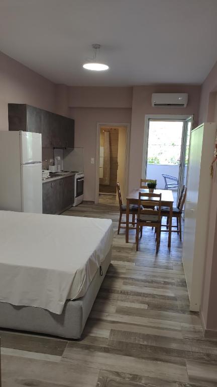a bedroom with a bed and a table and a kitchen at Deluxe Summer Studio Tolo in Tolo
