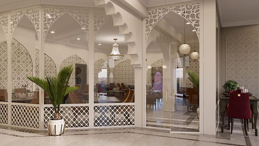 a dining room with a table and a potted plant at Reikartz Sote Tashkent in Tashkent
