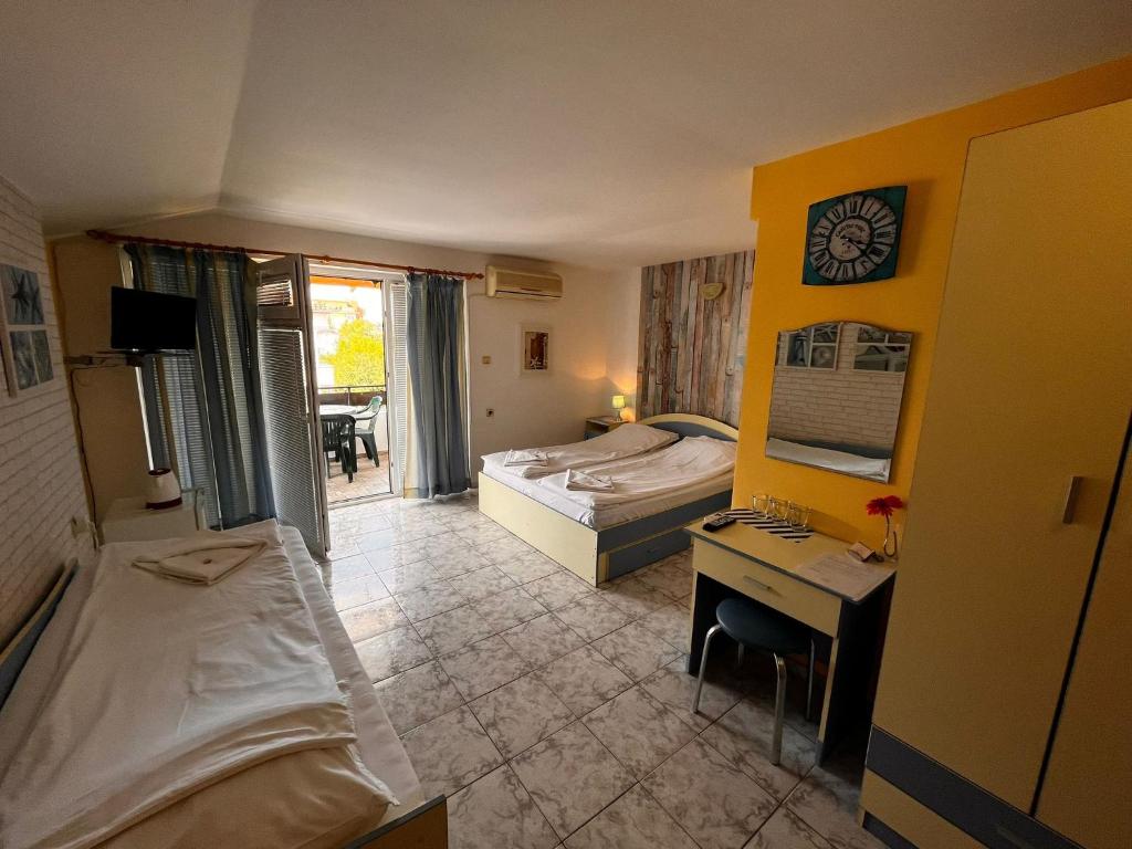 um quarto de hotel com um quarto com uma secretária e uma cama em Kъща за гости Христина em Lozenets