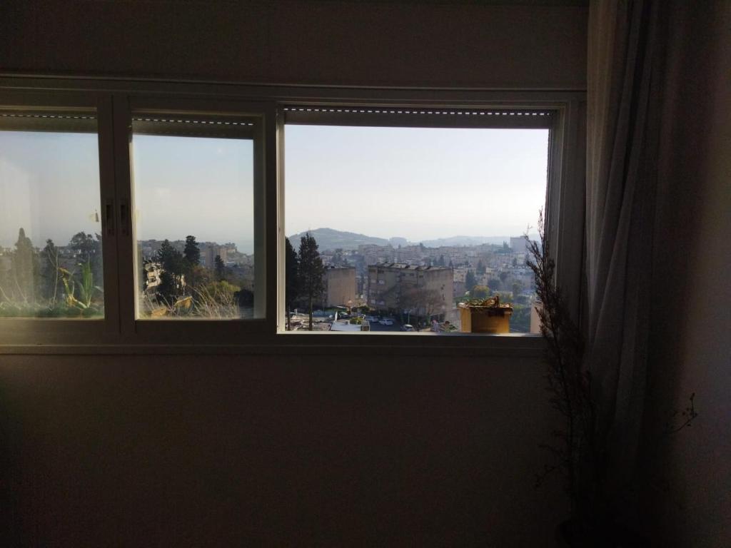 a window with a view of a city at Beach House Balcony in Yafo