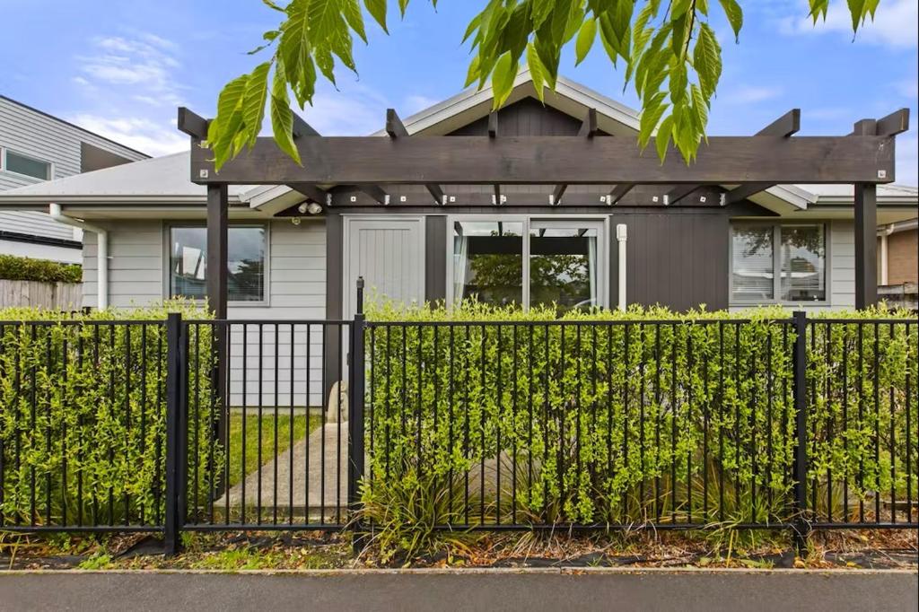 a black fence in front of a house at An elegant 2-bedroom house in Hamilton central. in Hamilton