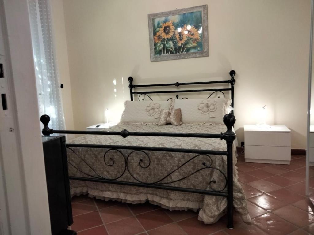 a bedroom with a black bed with a picture on the wall at La Casa di Lisa in San Vincenzo