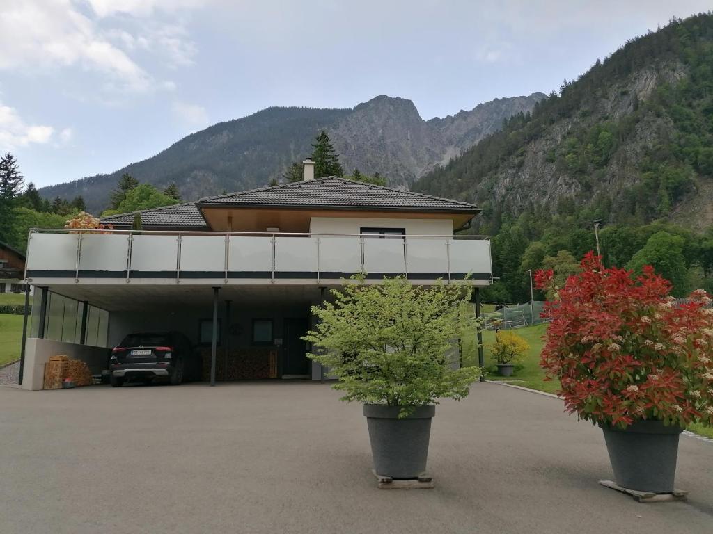a house with two potted plants in a parking lot at Ferienwohnung Ulrike in Sankt Anton im Montafon