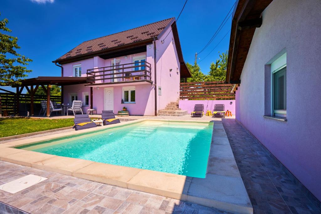 eine Villa mit einem Pool vor einem Haus in der Unterkunft Kuća za odmor s bazenom TeriHy in Klake