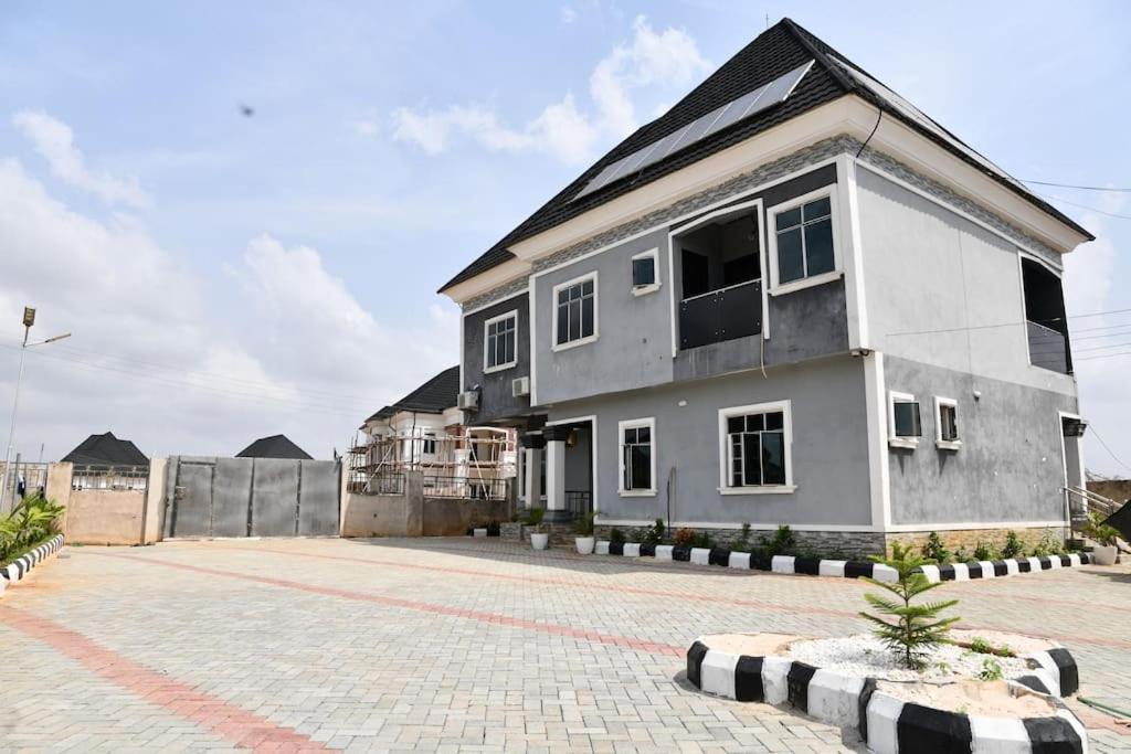 a white house with a black roof at Domi Smart 2 Bedroom Serviced Apartment with 24 hour Power in Benin City