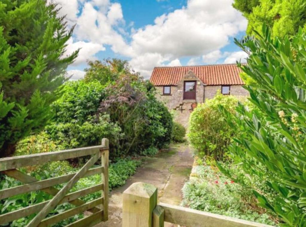 una casa con una valla de madera delante de ella en Tawny cottage w pool and enclosed garden en Pickering