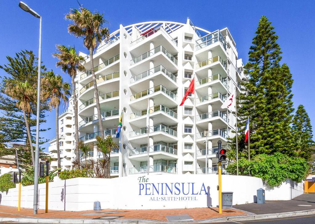 un gran edificio blanco con un cartel delante en Peninsula All Suite Hotel by Dream Resorts, en Ciudad del Cabo