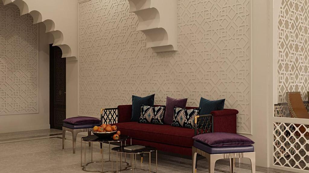 a living room with a red couch and two stools at Reikartz Sote Tashkent in Tashkent