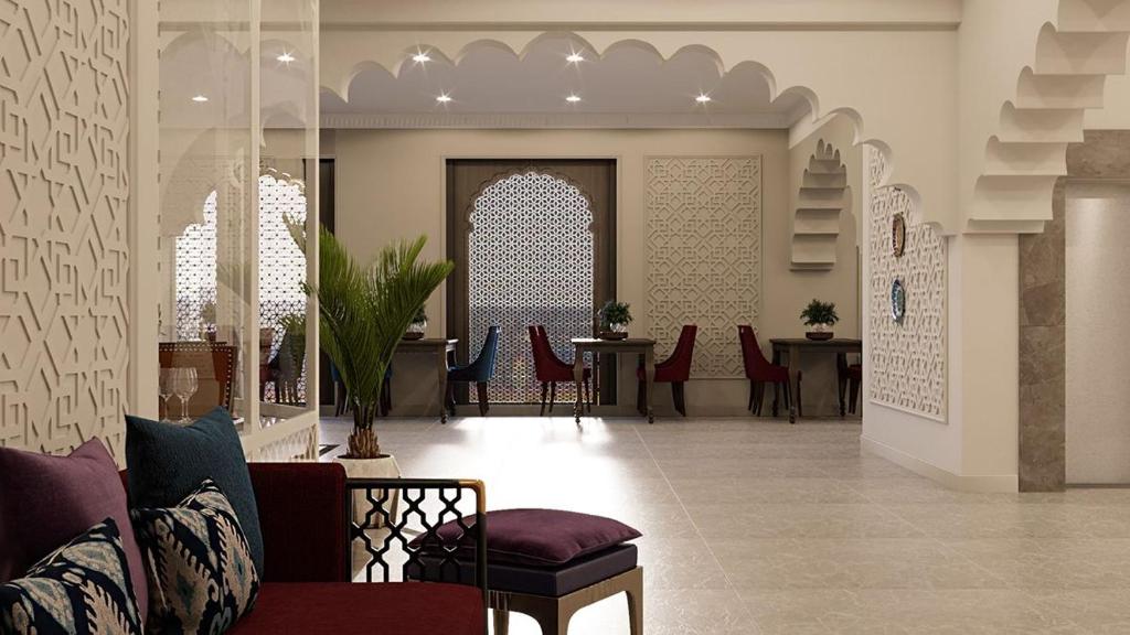 a lobby with red chairs and tables in a building at Reikartz Sote Tashkent in Tashkent
