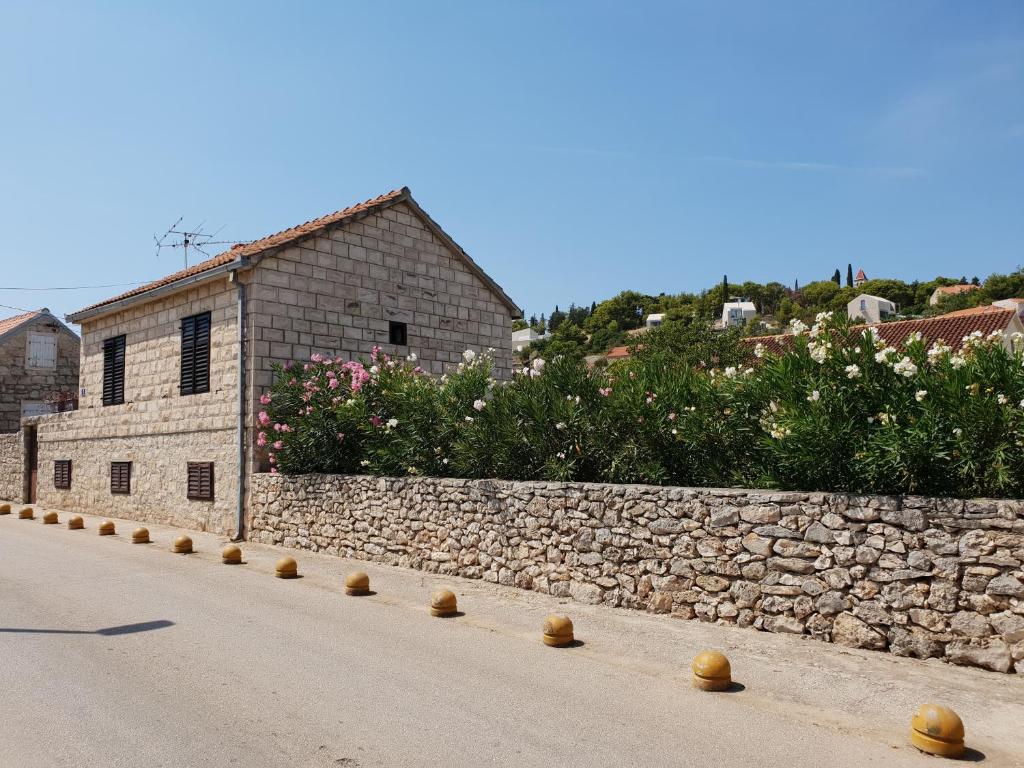 a stone wall next to a road with a building at Apartment Tereza in Sutivan