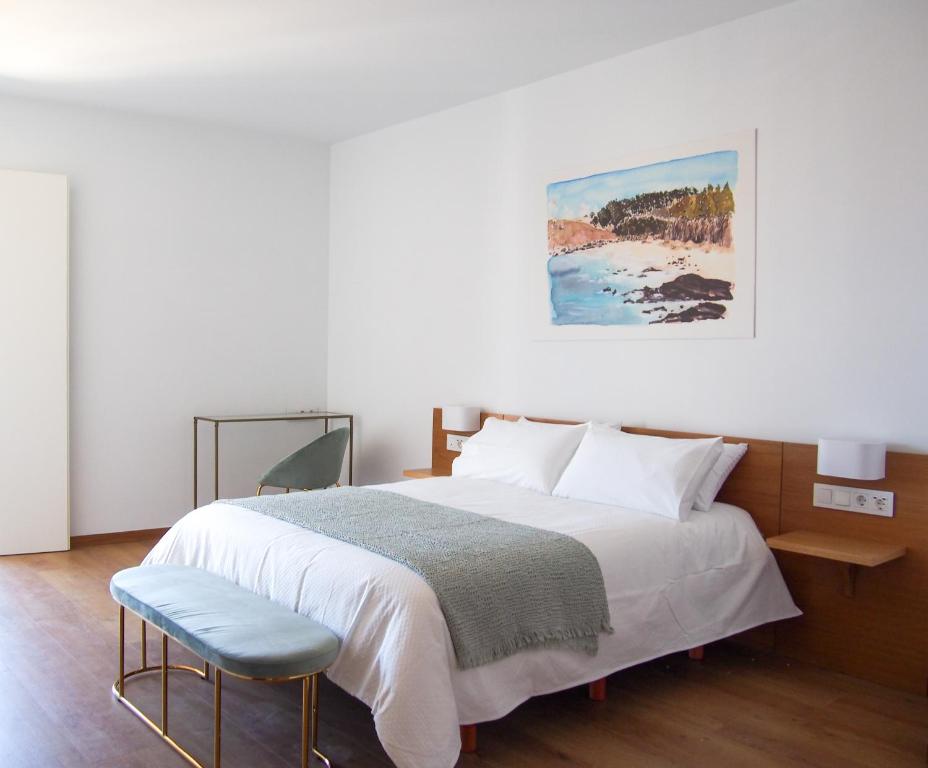 een slaapkamer met een groot bed en een stoel bij HOTEL BOUTIQUE VILAVELLA in O Grove