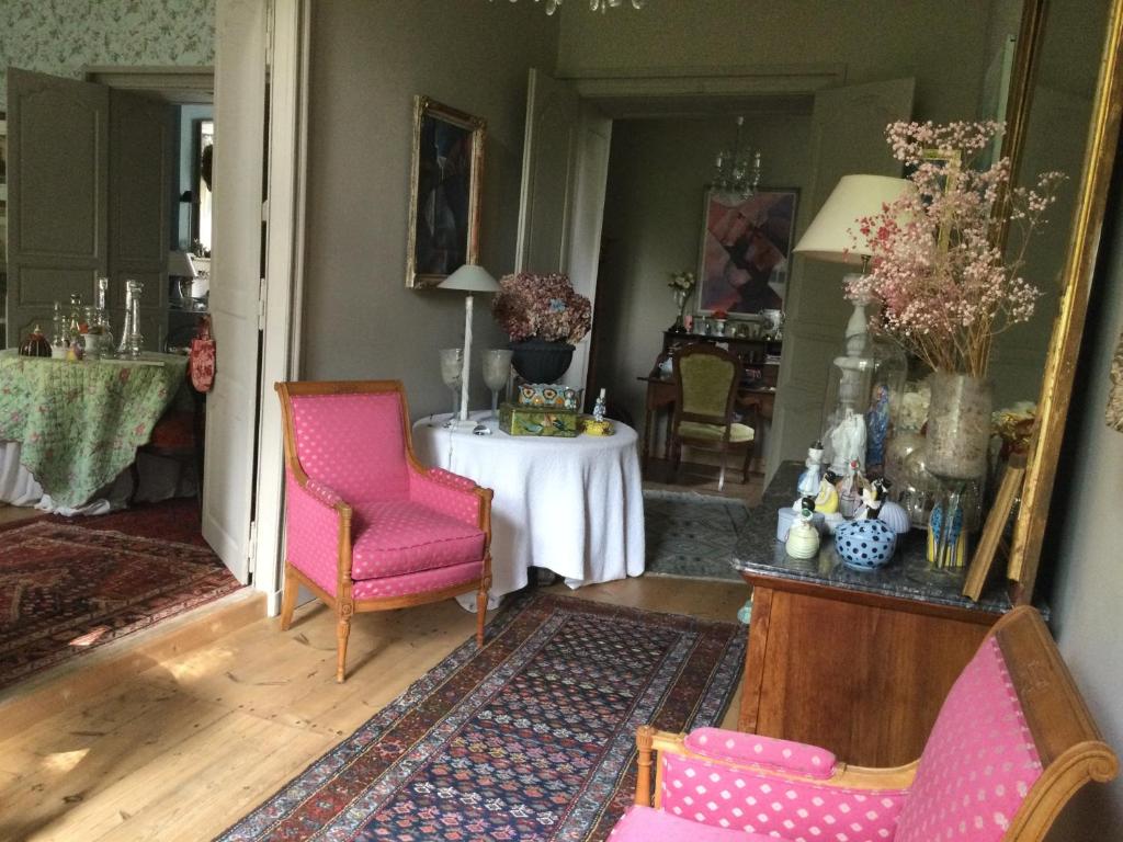 a room with a table and two chairs and a mirror at L’orangerie du Général in Saint-Jean-dʼAngély