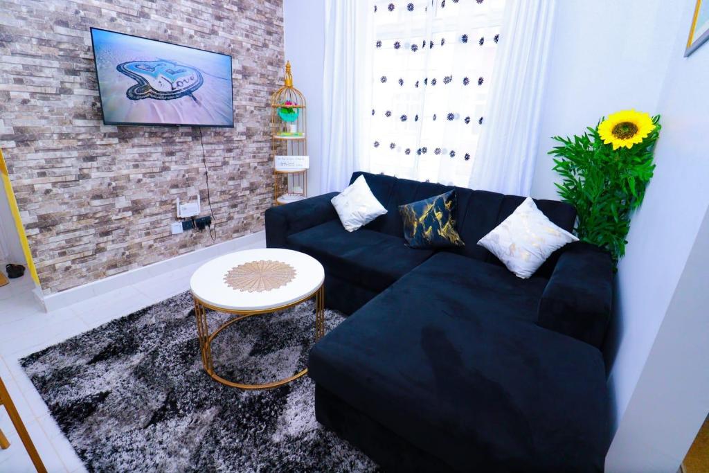 a living room with a black couch and a table at First class apartments in Kiambu