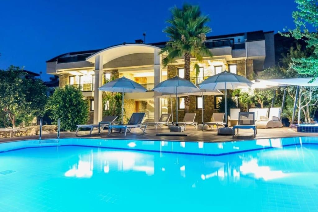 a house with a swimming pool with chairs and umbrellas at Villa Diamond in Marmaris