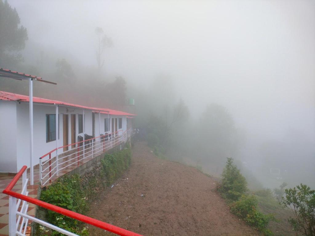 Gupta KāshiにあるShree Neelkanth Resortの丘の上の家の横の霧の道
