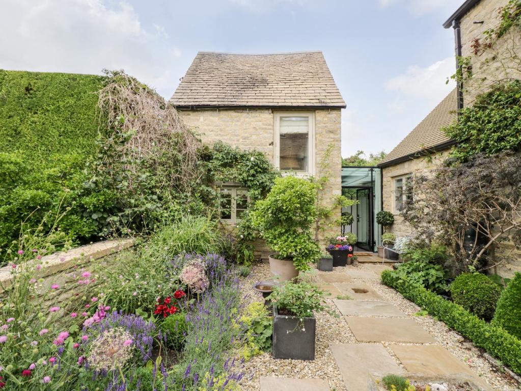 a garden in front of a house with plants at The Grain Store in Witney