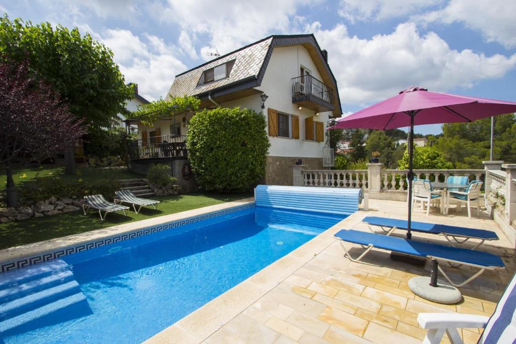 uma casa com uma piscina com um guarda-chuva roxo em Catalunya Casas Private paradise - hop, skip or jump to Barcelona! em Cervelló