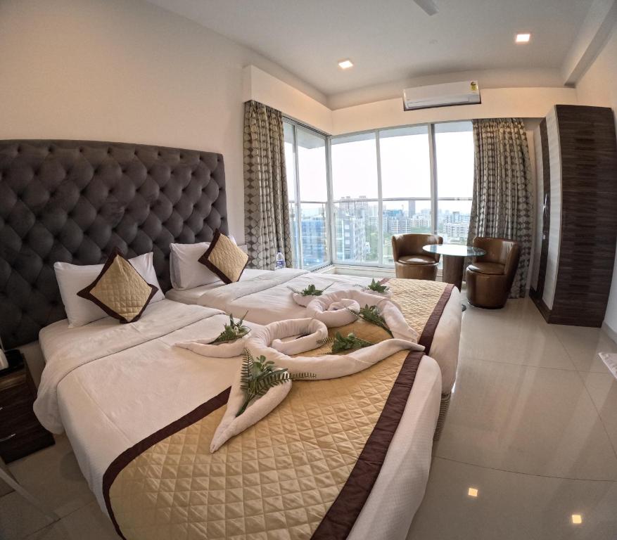 a bedroom with two beds and a large window at Maxxvalue Apartment Chandivali in Mumbai