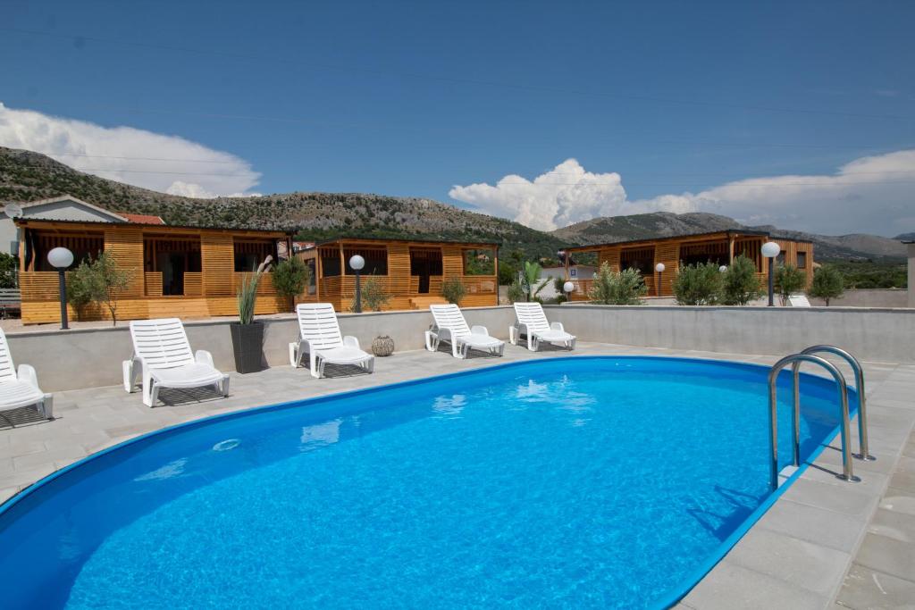 a large swimming pool with chairs and a house at Camp Ante-Gojko in Grebaštica