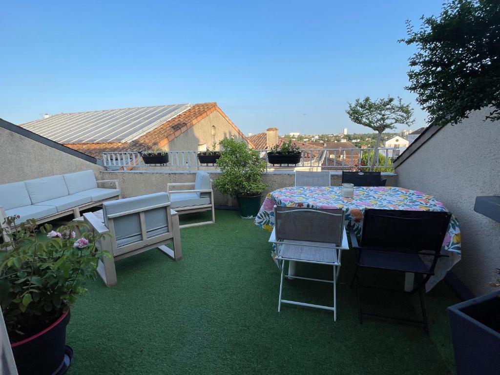 a patio with a table and chairs on a balcony at Grand Appartement Hypercentre avec Terrasse et Parking in Poitiers