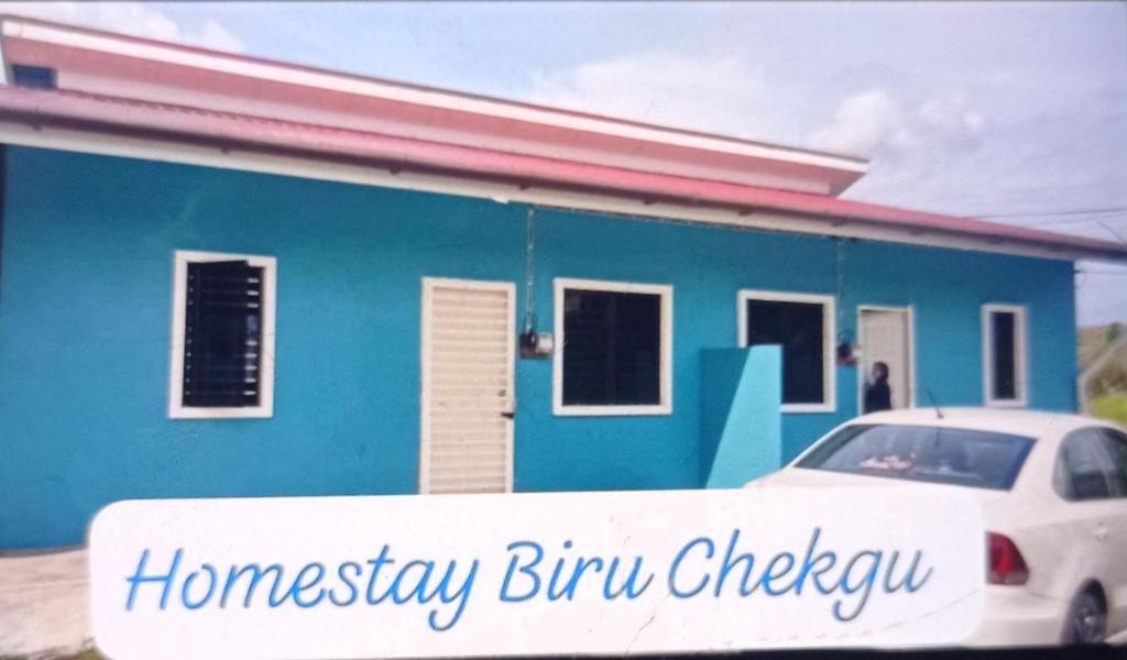 a blue house with a white car parked in front of it at Homestay Biru Chekgu in Kajang