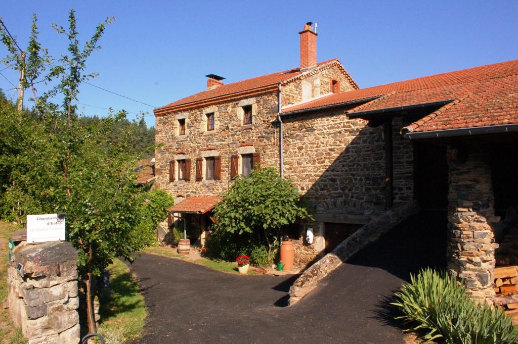 an old brick house with a driveway in front of it at Le Grand Trianon in Saint-Didier-sur-Doulon