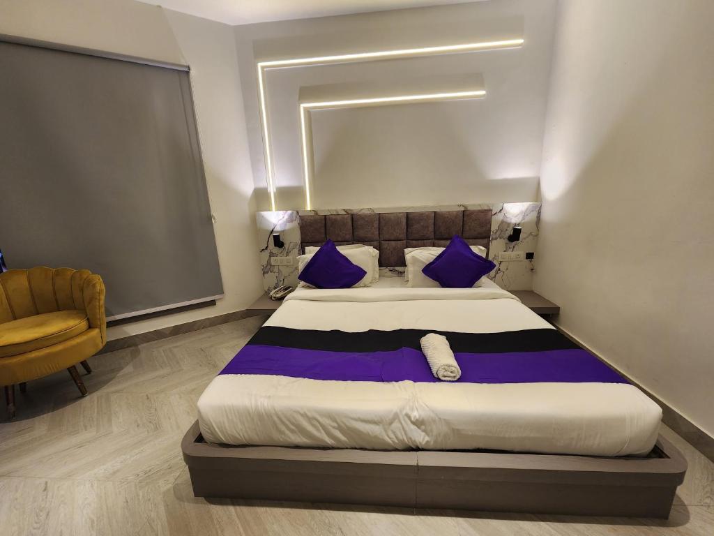 a bedroom with a large bed with blue pillows at Express Square9 in Gurgaon