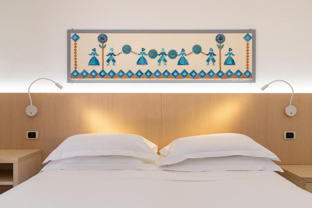 een slaapkamer met een bed met een foto erboven bij Hotel Corte Rosada in Porto Conte