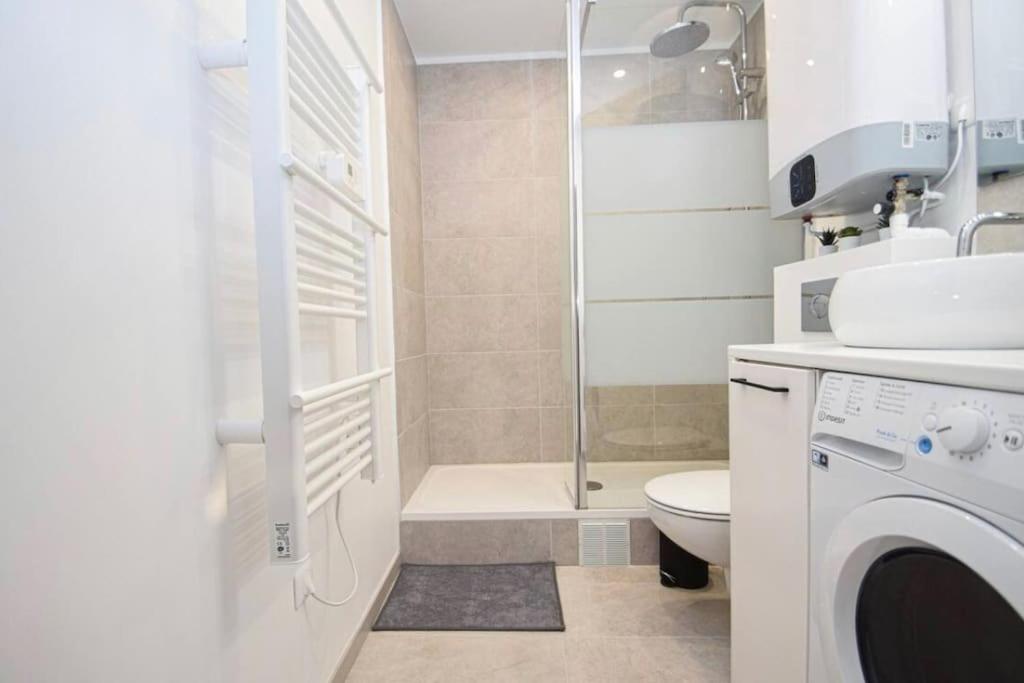 a bathroom with a shower toilet and a washing machine at Charmant 2P centre ville Orléans in Orléans