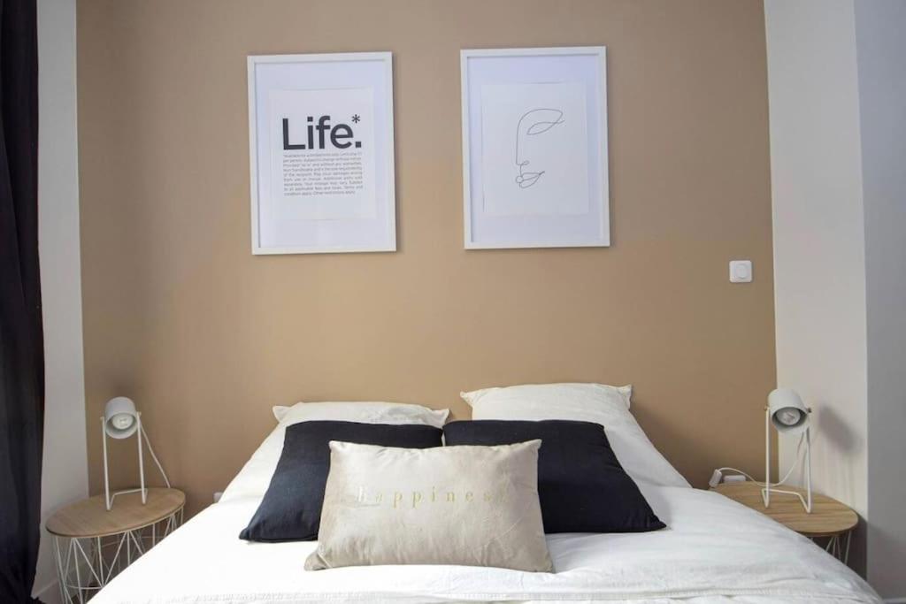 a bedroom with a bed with two pictures on the wall at Charmant 2P centre ville Orléans in Orléans
