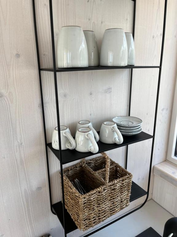 a shelf with dishes and bowls and a basket at BUQEZ ECO RESORT - Beach Villas 2 and 8 - Seaview, new wifi! in Drage