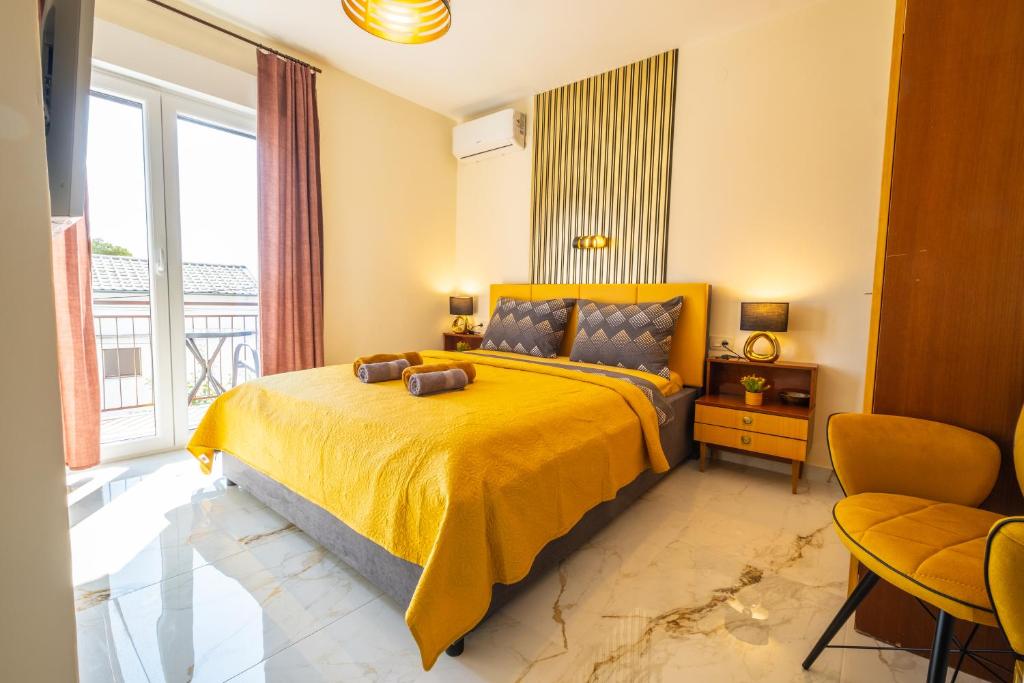 a bedroom with a bed with a yellow bedspread at Premium Relax Rooms in Novi Vinodolski